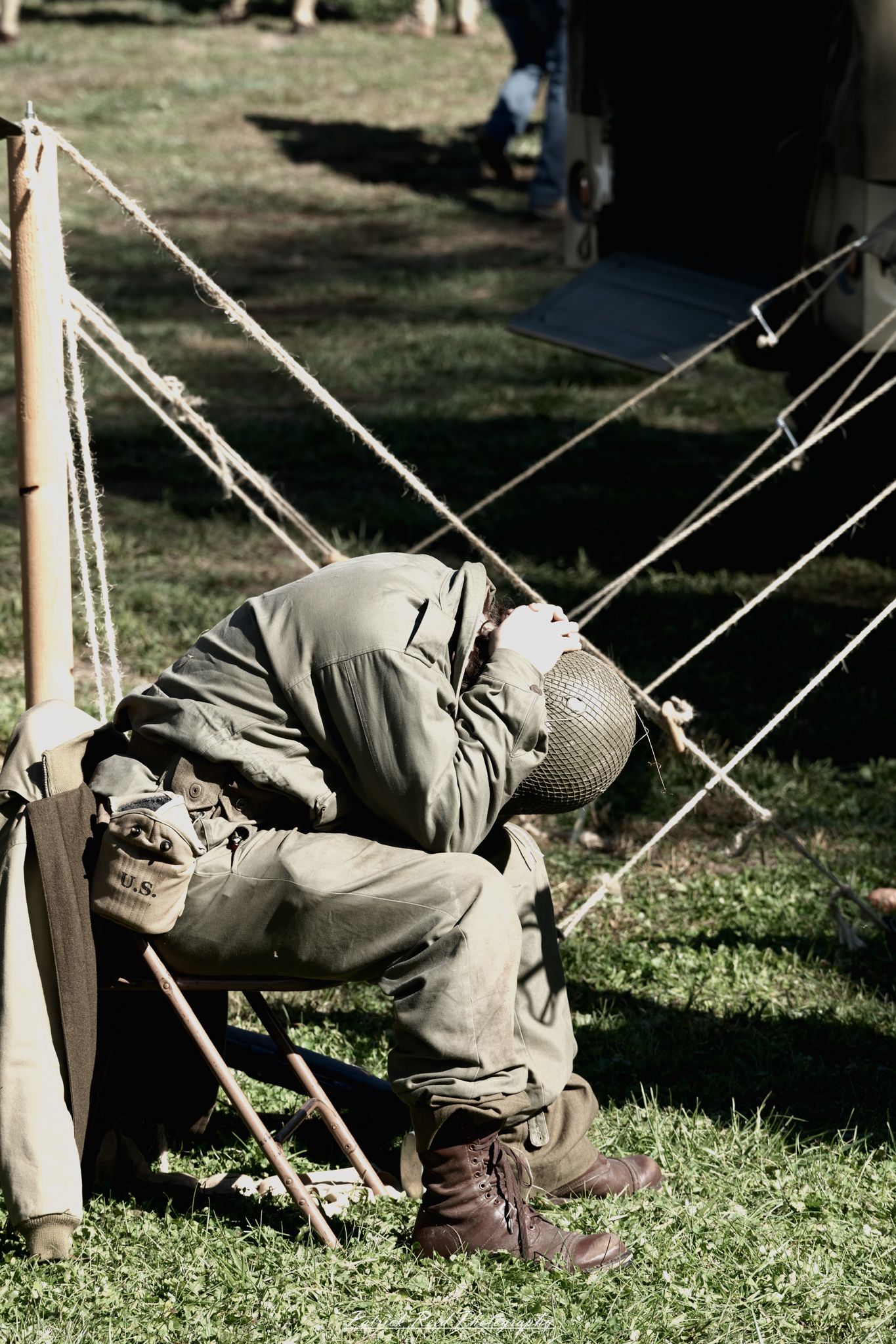 An American soldier sitting alone after battle, his face etched with exhaustion and trauma. His uniform is worn and dirt-streaked, and his hands tremble slightly as he stares into the distance, haunted by the memories of combat. The battlefield around him is eerily quiet, with smoke still rising in the background. His eyes reflect deep pain and the weight of his experiences, symbolizing the heavy toll of war on mental health.